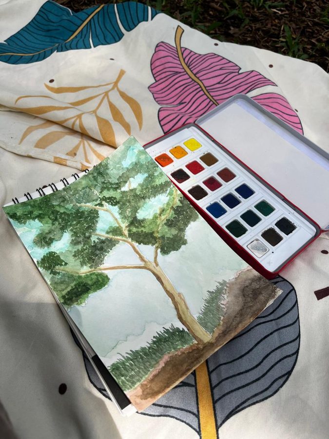 A watercolour painting of a tree next to a paint tin
